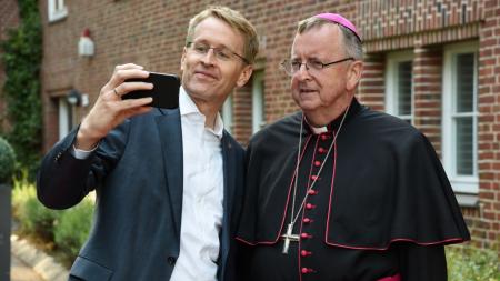 Ministerpräsident Daniel Günther und Weihbischof Horst Eberlein machen ein Selfie. 
